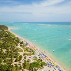 Vista da praia de águas turquesa com várias barracas